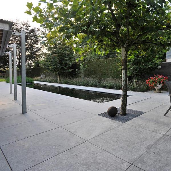 Terras met natuursteen tegels en strakke vijver